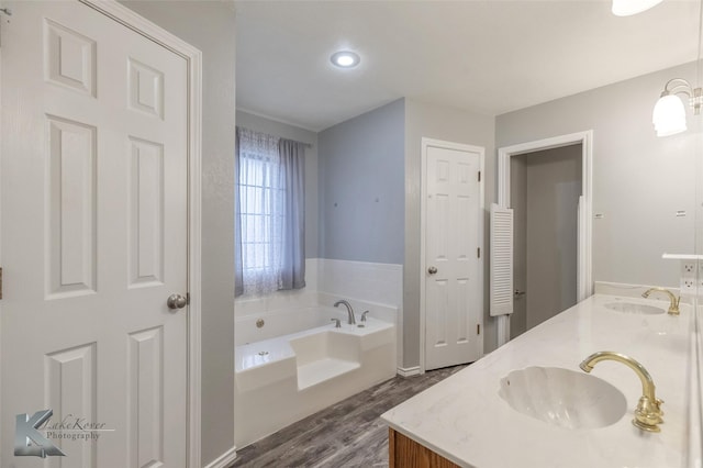 bathroom with vanity, hardwood / wood-style floors, and a bathing tub