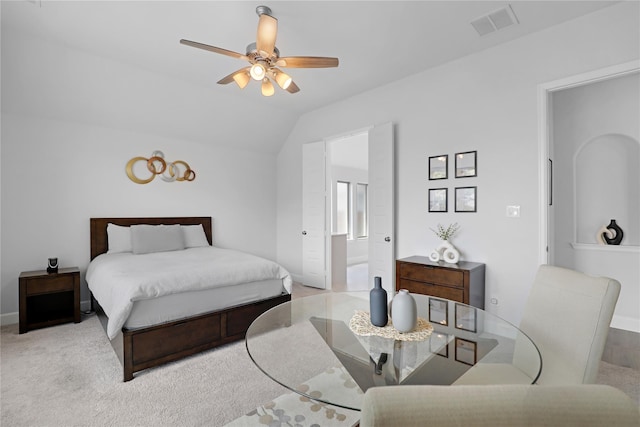 bedroom featuring light colored carpet, vaulted ceiling, ceiling fan, and ensuite bathroom