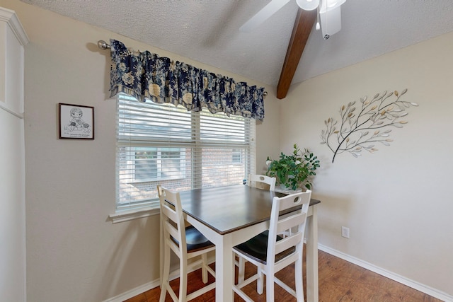 dining area featuring beam ceiling, a textured ceiling, ceiling fan, and wood-type flooring