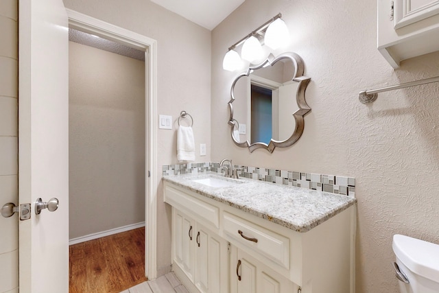 bathroom with hardwood / wood-style floors, vanity, and toilet