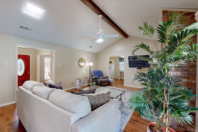 living room featuring lofted ceiling with beams, hardwood / wood-style flooring, and ceiling fan