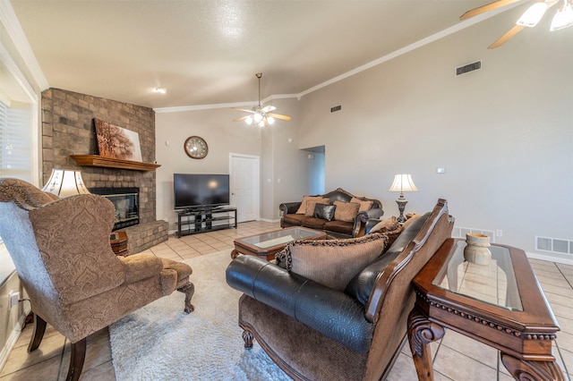 living room with a ceiling fan, tile patterned flooring, a brick fireplace, crown molding, and baseboards