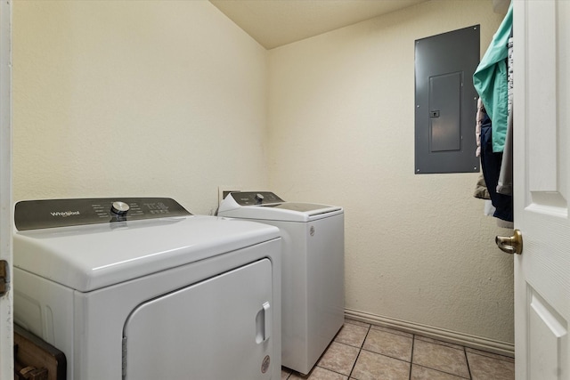 clothes washing area featuring electric panel, light tile patterned floors, and independent washer and dryer