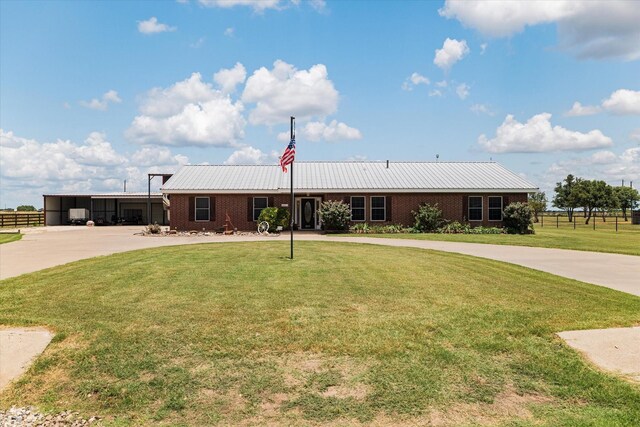 ranch-style home featuring curved driveway, brick siding, and metal roof