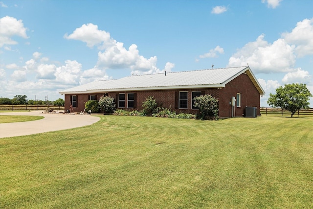 rear view of house with a lawn and central AC unit