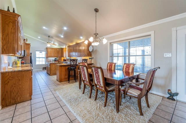 dining area featuring lofted ceiling, ceiling fan with notable chandelier, crown molding, and light tile patterned flooring