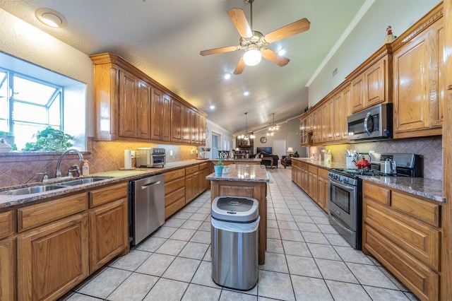 kitchen with a center island, sink, stainless steel appliances, backsplash, and light tile patterned floors