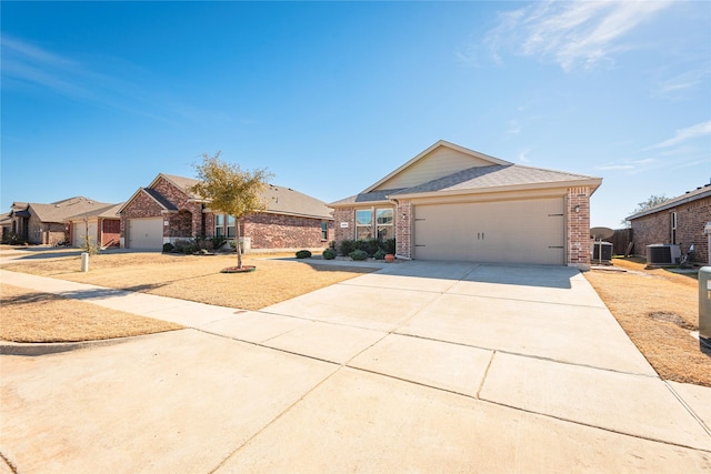 ranch-style house featuring central AC unit, concrete driveway, an attached garage, a gate, and brick siding