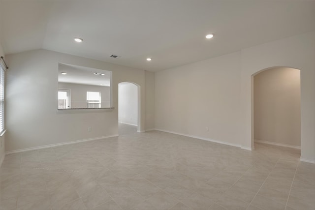 unfurnished room featuring light tile patterned floors and vaulted ceiling