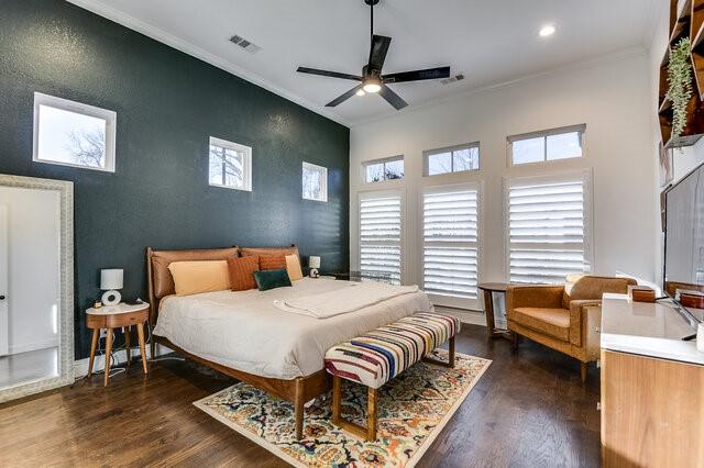 bedroom with ceiling fan, crown molding, and dark wood-type flooring