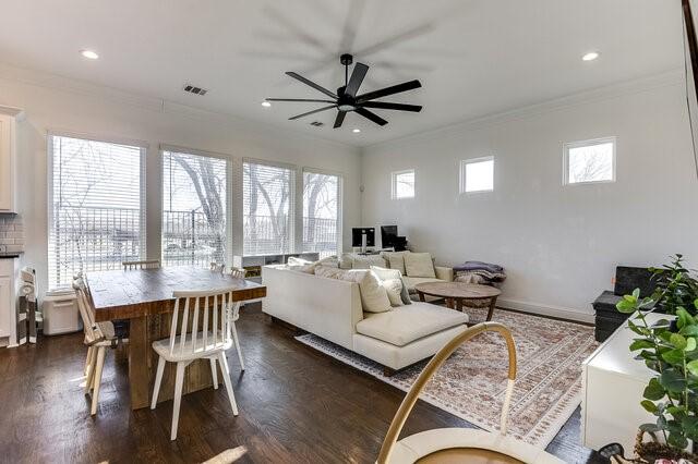 living room with ceiling fan, crown molding, and dark wood-type flooring