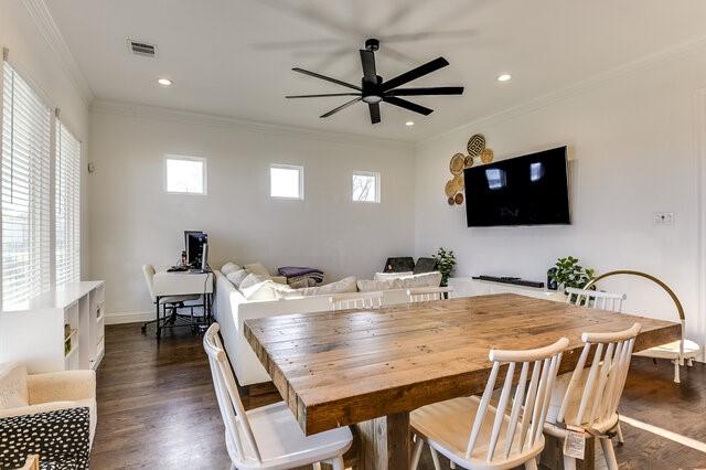 dining area with a wealth of natural light, dark hardwood / wood-style floors, ceiling fan, and ornamental molding