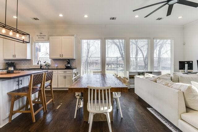 kitchen with dark hardwood / wood-style floors, decorative backsplash, a wealth of natural light, decorative light fixtures, and white cabinetry