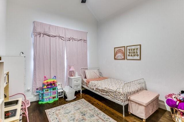 bedroom with dark hardwood / wood-style floors and vaulted ceiling