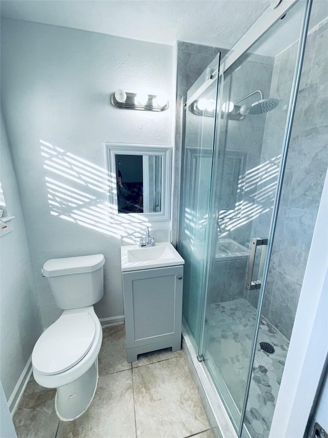 bathroom with an enclosed shower, vanity, tile patterned flooring, and toilet