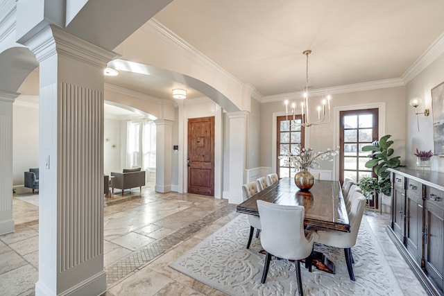 dining space featuring a notable chandelier, crown molding, and ornate columns