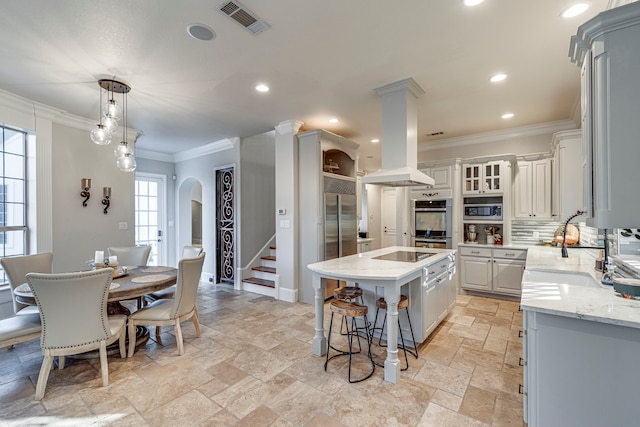 kitchen featuring sink, appliances with stainless steel finishes, tasteful backsplash, island range hood, and a kitchen island