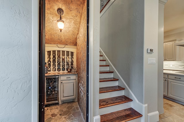 wine cellar with ornamental molding and beverage cooler