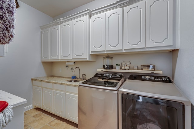 laundry room featuring cabinets, washing machine and dryer, and sink