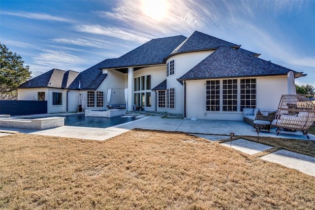 rear view of property featuring a pool with hot tub, a yard, a patio area, and outdoor lounge area