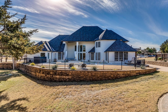 rear view of house with a lawn and a patio area