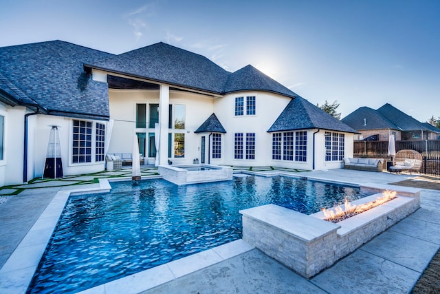 view of swimming pool with an in ground hot tub, a patio, and an outdoor living space with a fire pit