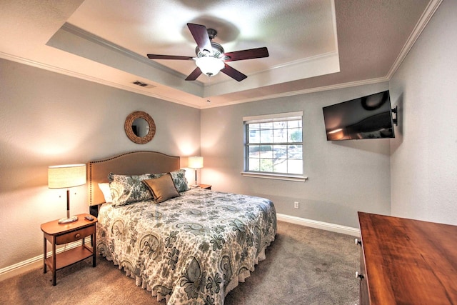 carpeted bedroom featuring a tray ceiling, ceiling fan, and ornamental molding