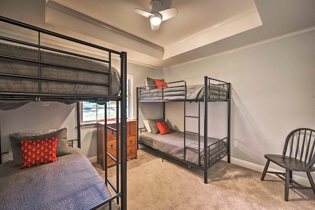 bedroom with carpet floors, a raised ceiling, ceiling fan, and crown molding