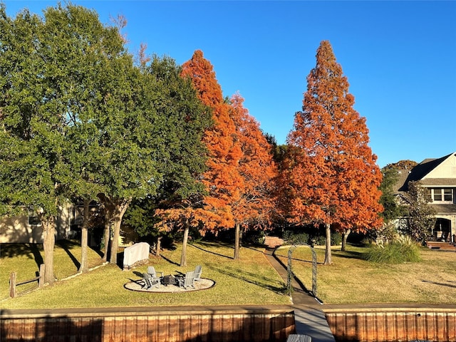 view of home's community featuring a lawn and an outdoor fire pit