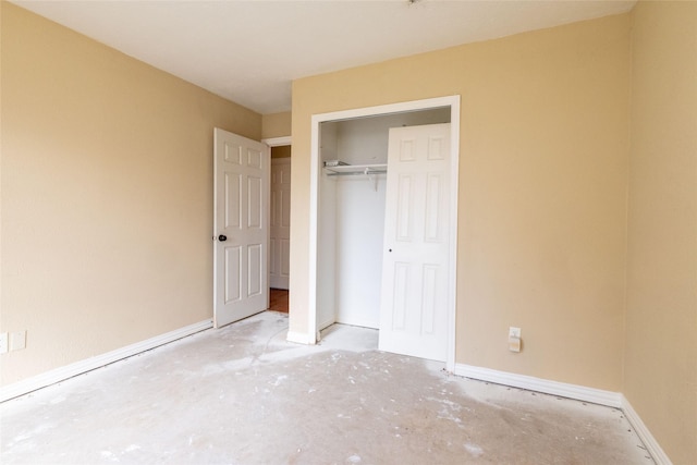 unfurnished bedroom with concrete floors and a closet