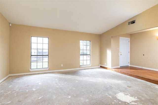 unfurnished room featuring lofted ceiling and concrete floors