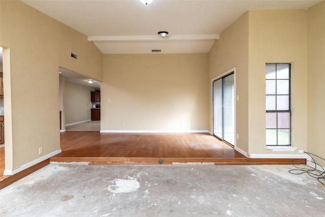 spare room with hardwood / wood-style floors and vaulted ceiling with beams