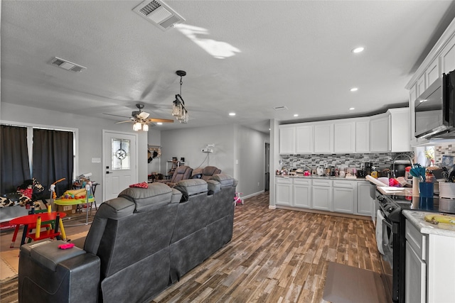 kitchen with backsplash, black range with electric stovetop, ceiling fan, hardwood / wood-style flooring, and white cabinetry