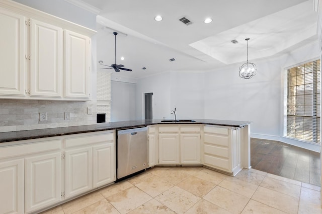 kitchen with white cabinets, stainless steel appliances, wall chimney exhaust hood, and tasteful backsplash