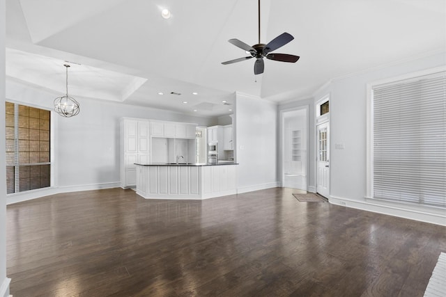 unfurnished living room with ceiling fan with notable chandelier, dark hardwood / wood-style flooring, and sink