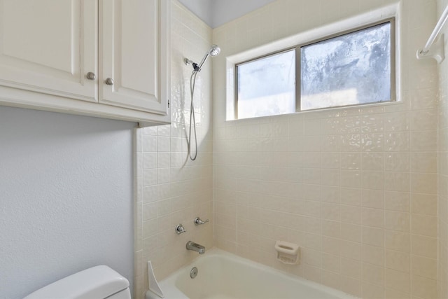 bathroom featuring toilet and tiled shower / bath combo