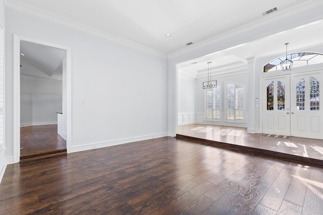 foyer featuring ornamental molding, dark hardwood / wood-style flooring, and an inviting chandelier