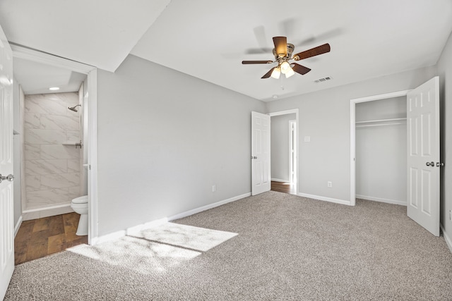 unfurnished bedroom featuring ensuite bathroom, ceiling fan, carpet floors, and a closet