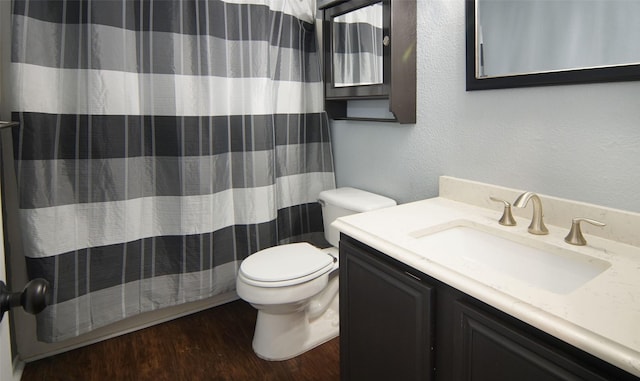 bathroom with toilet, vanity, and hardwood / wood-style flooring