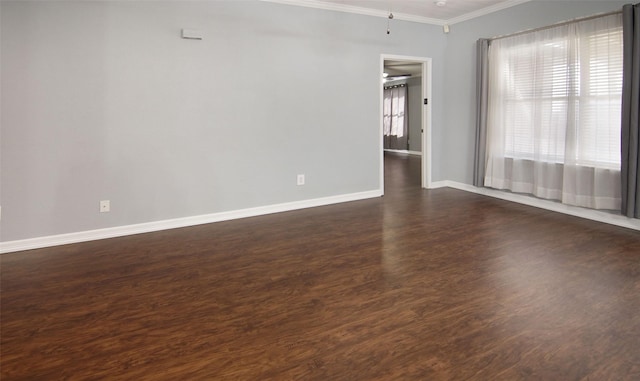 spare room featuring crown molding and dark wood-type flooring