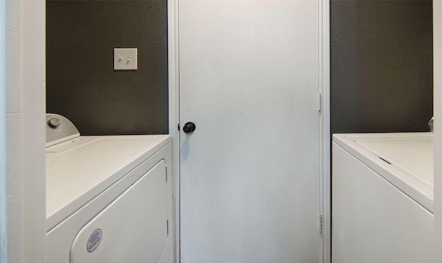 clothes washing area featuring separate washer and dryer