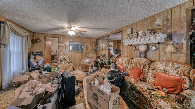 misc room featuring ceiling fan, a textured ceiling, and wooden walls