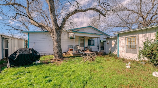 rear view of property featuring a yard