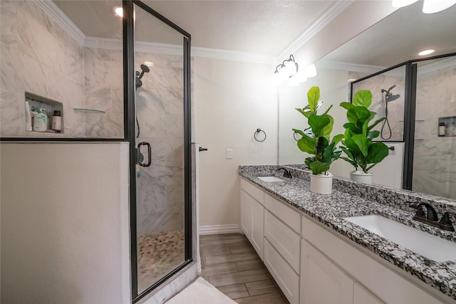 bathroom featuring vanity, a shower with shower door, and ornamental molding