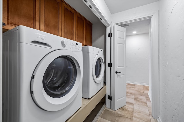 laundry area with cabinets and washing machine and dryer