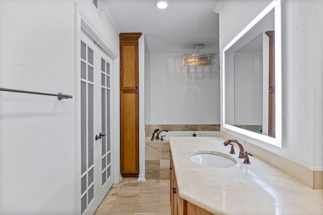 bathroom featuring a bathing tub, vanity, and crown molding