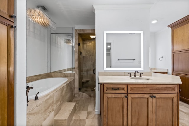 bathroom featuring separate shower and tub, an inviting chandelier, vanity, and ornamental molding