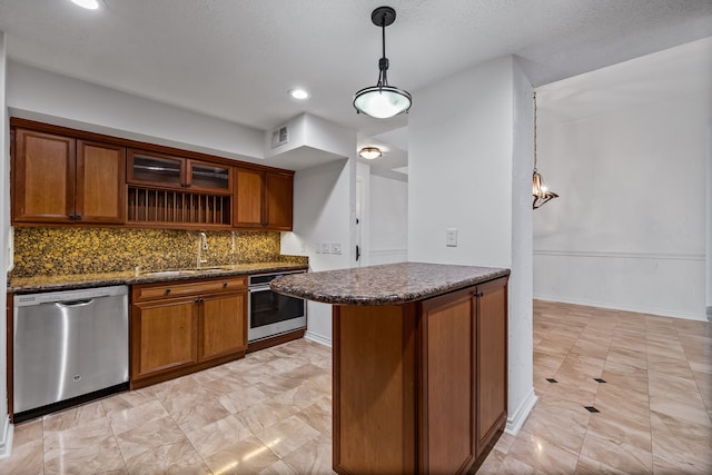 kitchen with sink, stainless steel appliances, kitchen peninsula, decorative light fixtures, and decorative backsplash