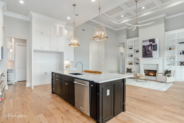 kitchen featuring coffered ceiling, sink, a center island with sink, dishwasher, and a high ceiling