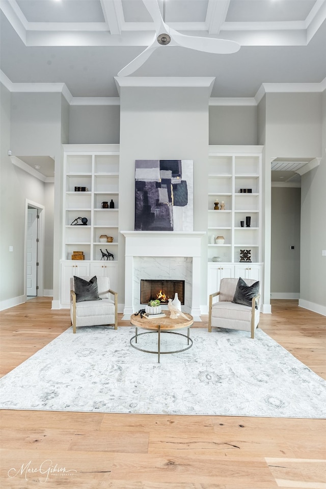 living room with ornamental molding, wood finished floors, baseboards, and a premium fireplace